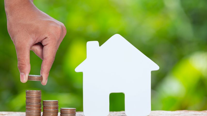 World Habitat Day,close up picture of a pile of coins and a model house